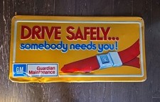 Vintage GM Guardian Maintenance "Drive Safely... Somebody Needs You!" Embossed Metal Seat Belt Advertising Sign