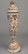 Pair of Italian Capodimonte-Style Covered Urns with Figural Cherub Finials and Relief Putti Scenes