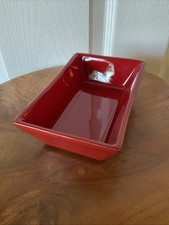 Ceramic item with red transfer-printed backstamp, maker unidentified (mark too blurred/smudged to read)