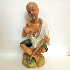 Ceramic Figurine of a Seated Barefoot Man Holding an Apple