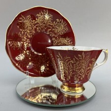 Porcelain Teacup and Saucer with Gold Scrolling Vine Pattern on Cream Ground