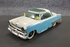 Blurry photograph of a vintage die-cast or tin toy automobile — listing 5